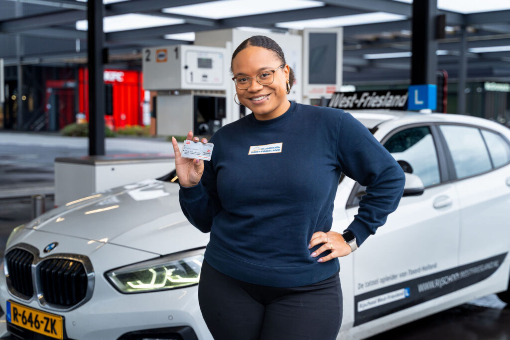 Vrouwelijke rij-instructrice houdt een AVIA Card vast.